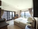 Spacious bedroom with large windows offering city views