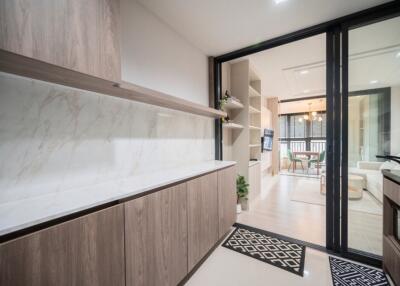 Modern kitchen with marble backsplash and view into living area