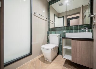 Modern bathroom with toilet, sink, mirror, and storage