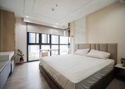 Spacious bedroom with large window and modern furnishings