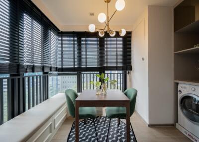 Bright dining area with modern chandelier and adjacent laundry space