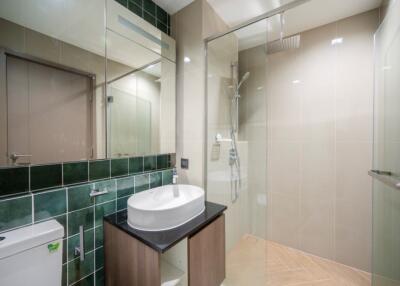 Modern bathroom with green tiles and glass shower