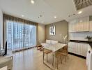 Modern living room with light wood flooring, large windows, and a small dining area