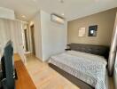 Modern bedroom with a double bed, air conditioner, and flat-screen TV.