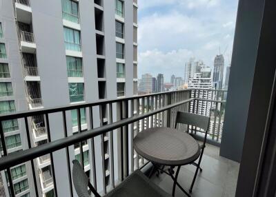 Balcony view with table and chairs overlooking cityscape