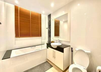 Modern bathroom with bathtub, sink, and toilet