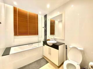 Modern bathroom with bathtub, sink, and toilet