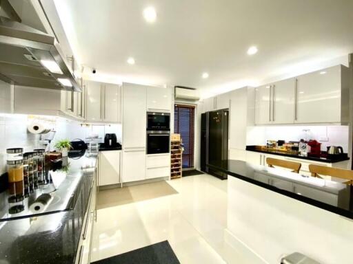 modern kitchen with white cabinets, stainless steel appliances, and black countertops