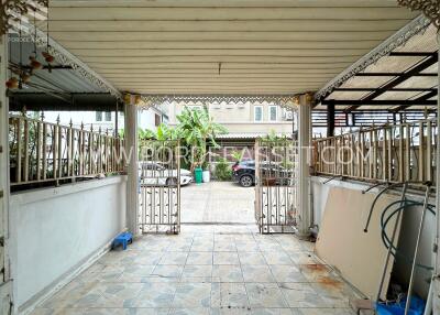 Covered carport with tiled flooring and decorative metal fencing