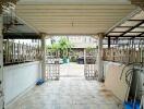 Covered carport with tiled flooring and decorative metal fencing