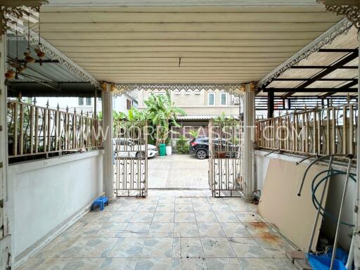 Covered carport with tiled flooring and decorative metal fencing