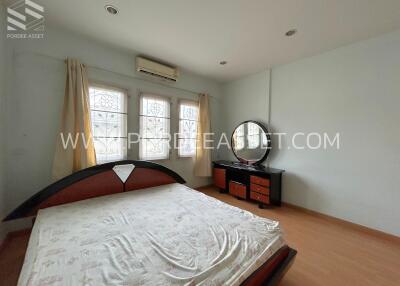 Bedroom with bed, dresser, windows, and air conditioning unit