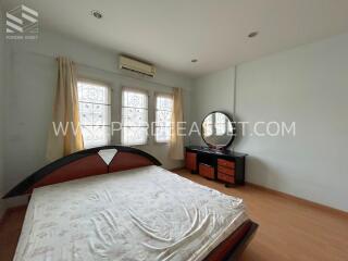 Bedroom with bed, dresser, windows, and air conditioning unit