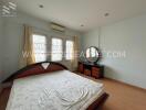 Bedroom with bed, dresser, windows, and air conditioning unit