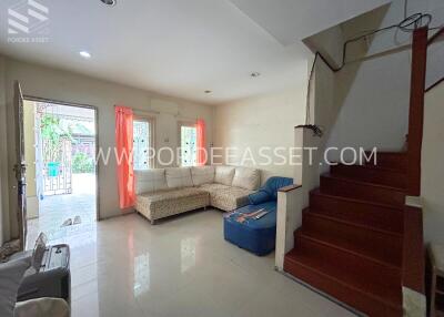 Spacious and well-lit living room with furniture and staircase