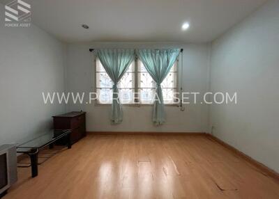 Spacious bedroom with wooden flooring and large window