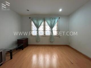 Spacious bedroom with wooden flooring and large window