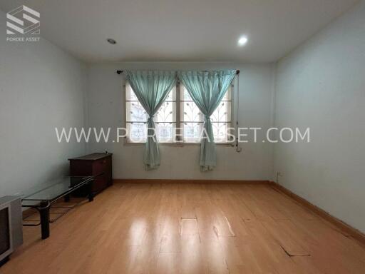 Spacious bedroom with wooden flooring and large window