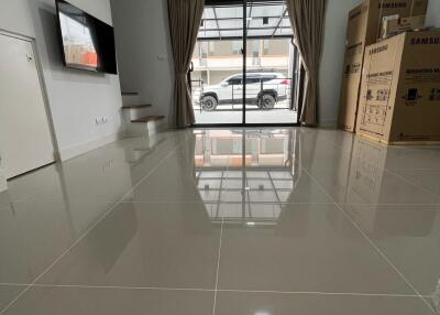 Spacious living room with large window and tiled floor