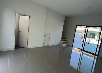 modern living room with large tiles, open door to stairs and balcony view