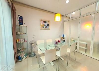 Spacious dining area with glass table and white chairs