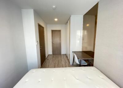 Minimalist bedroom with wooden floor and a desk