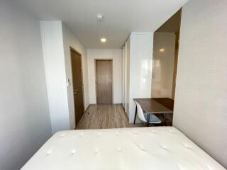 Minimalist bedroom with wooden floor and a desk