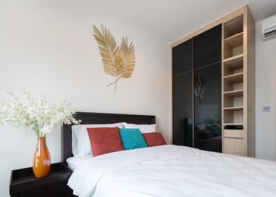 Modern bedroom with bed, wall decor, built-in wardrobe, and air conditioning