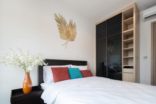 Modern bedroom with bed, wall decor, built-in wardrobe, and air conditioning