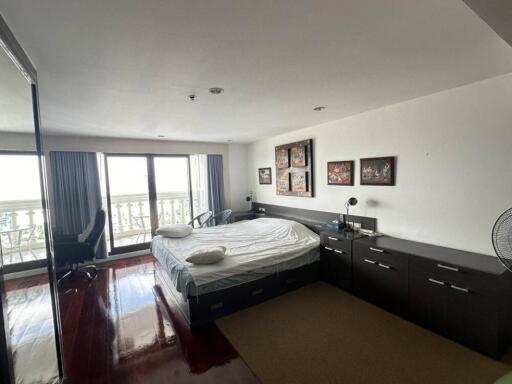 Master bedroom with large windows and modern furniture