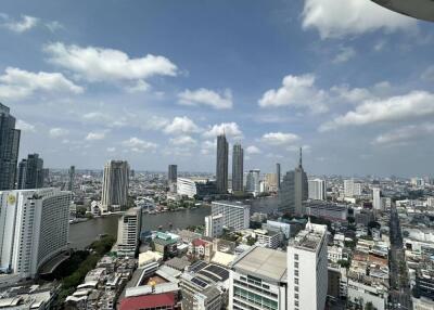 High-rise view of city buildings with river and cloudy sky