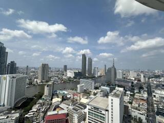 High-rise view of city buildings with river and cloudy sky