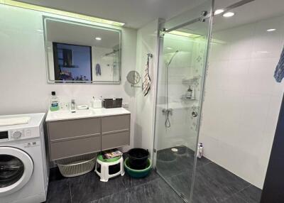 Modern bathroom with walk-in shower and laundry area