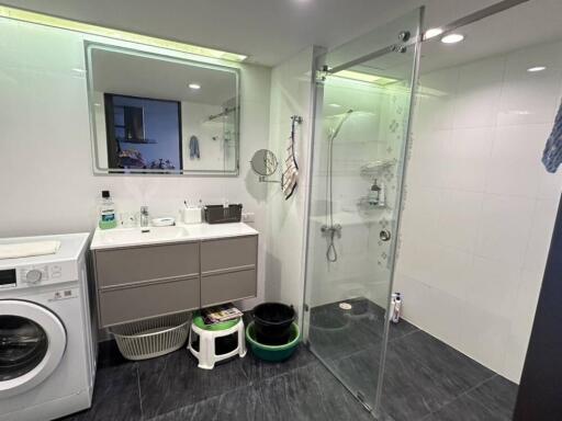 Modern bathroom with walk-in shower and laundry area