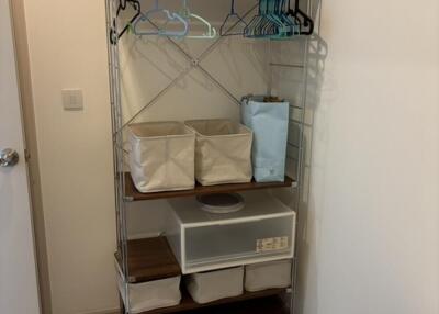 Clothing rack with baskets and hangers in a bedroom