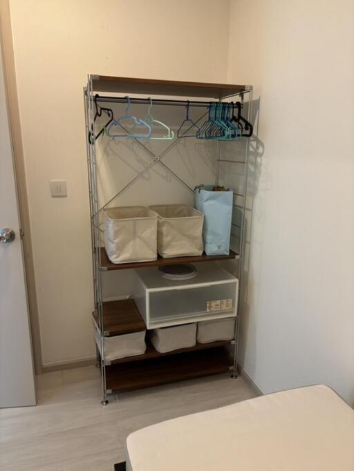 Clothing rack with baskets and hangers in a bedroom