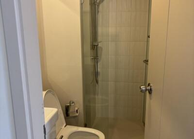 Modern bathroom with toilet, sink, and glass shower