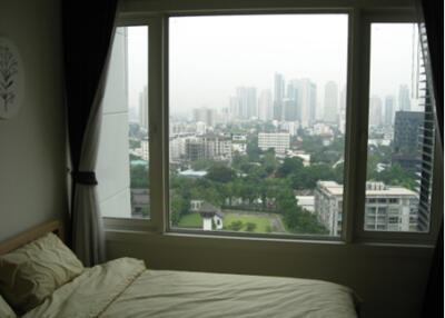 Bedroom with a large window overlooking the cityscape