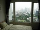 Bedroom with a large window overlooking the cityscape