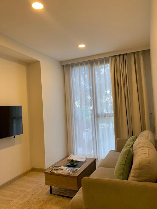 Modern living room with sofa, coffee table, and wall-mounted TV