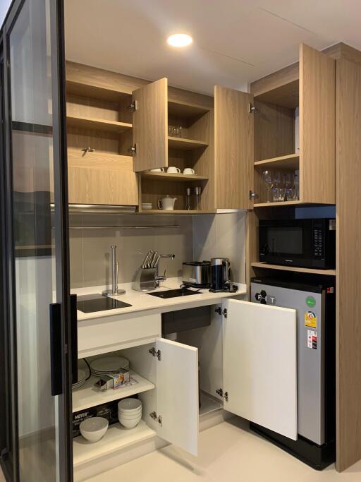 Compact modern kitchen with appliances and open cabinets