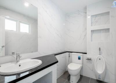 Modern bathroom with sink, toilet, urinal, and built-in shelves