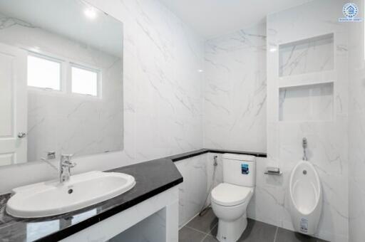 Modern bathroom with sink, toilet, urinal, and built-in shelves