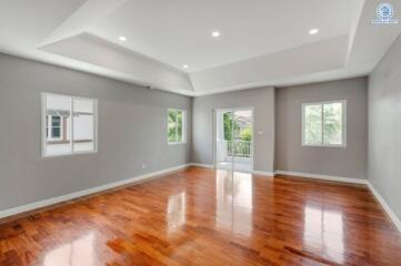 Spacious living room with wooden flooring and ample natural light