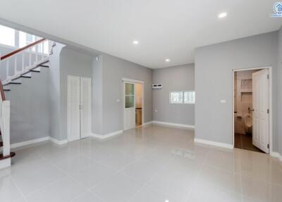 Spacious living area with staircase and adjacent rooms