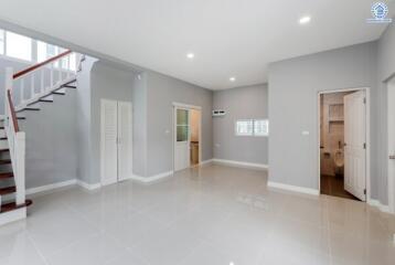 Spacious living area with staircase and adjacent rooms