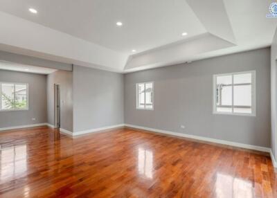 Spacious living room with polished hardwood floors and recessed lighting