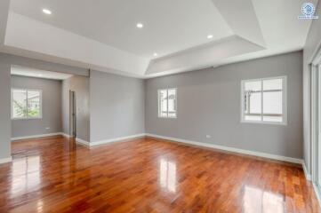 Spacious living room with polished hardwood floors and recessed lighting