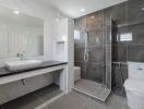 Modern bathroom with a large mirror, sink, toilet, and walk-in shower