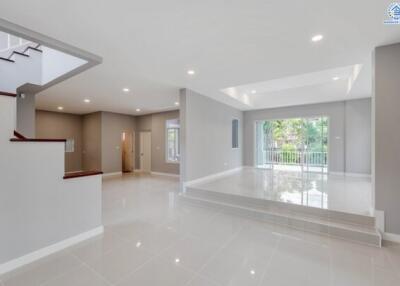 Spacious modern living area with large windows and glossy tiled floor